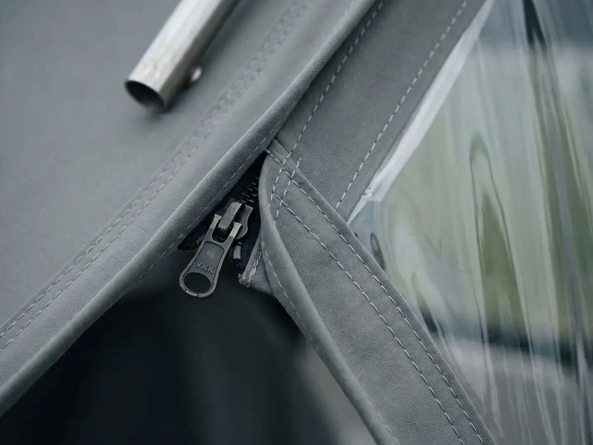 Macro van een nieuwe rits en helder kapraam met strakke stiknaad in een sprayhood