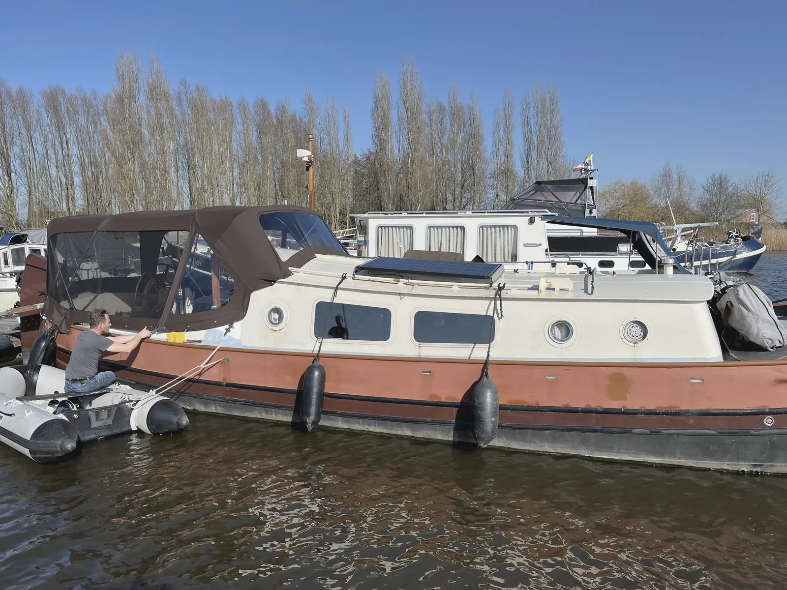 Klassieke motorboot met kajuitkap op maat, afgemeerd langs de rietkraag op de Loosdrechtse Plassen